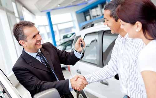 An Idaho Motor Vehicle Dealer hands car keys to new owners